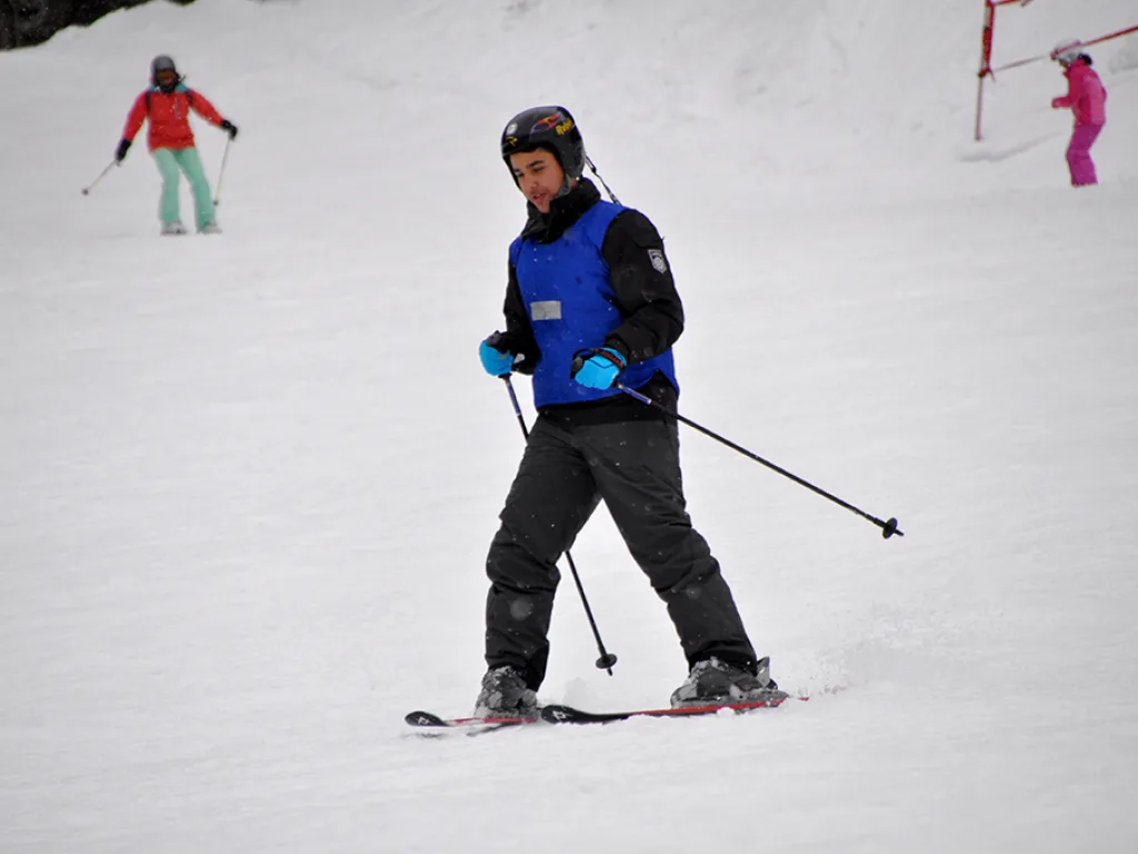 Skifahrer steht mit ausgebreiteten Armen auf der Piste.
